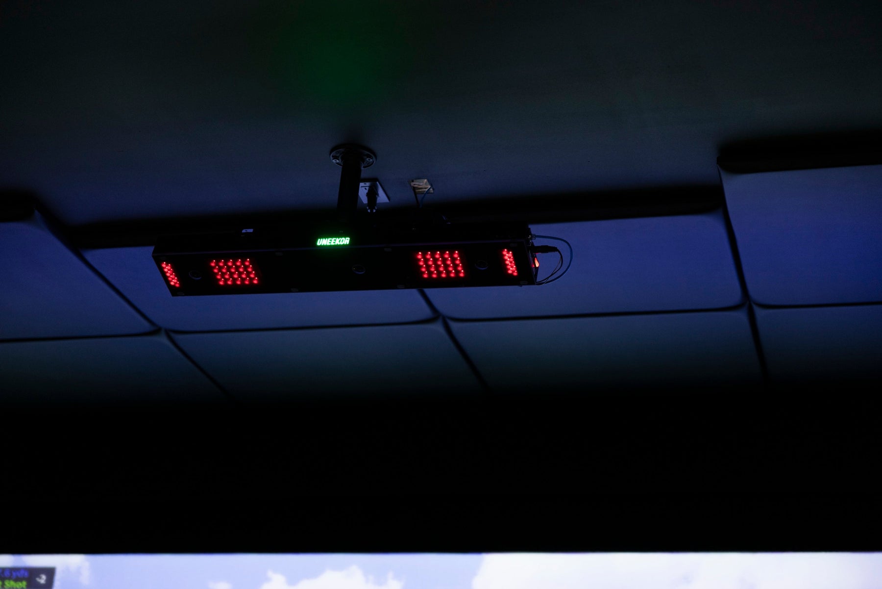 Uneekor EYE XO2 launch monitor mounted on the ceiling above a hitting area