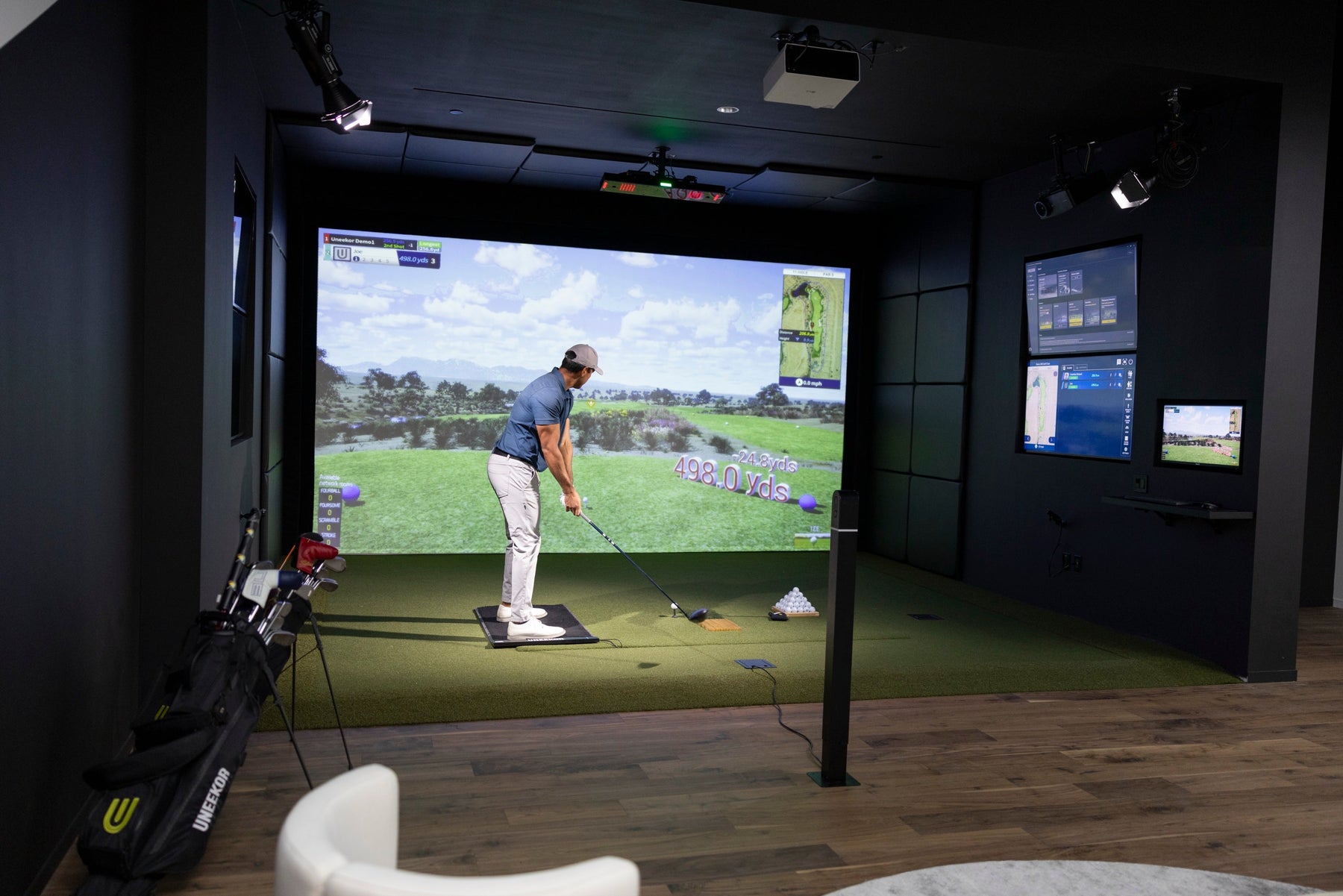 Golfer swinging in a simulator with the Uneekor EYE XO2 mounted overhead
