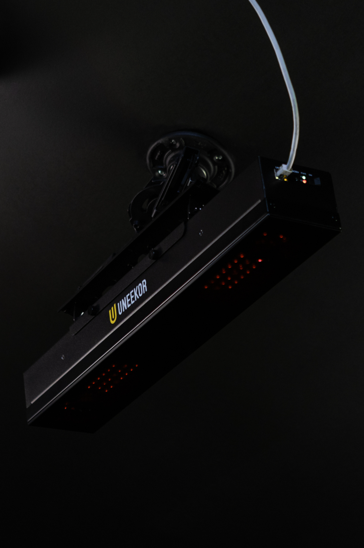 Uneekor Eye XR launch monitor mounted at an angle with cable connection and Uneekor logo visible