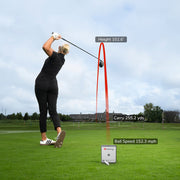 Person playing golf on a green field with digital display showing performance metrics using a Mevo Gen2 Launch Monitor