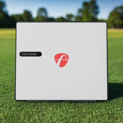 FlightScope X3C launch monitor viewed straight on from the front, showing its flat white face with red logo and Fusion Tracking label, standing on grass