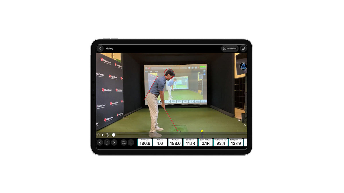 Tablet showing the FS Golf app swing video gallery, with a recorded swing clip, a club path line overlay, and readouts for carry, roll, total distance, lateral and curve distance, club speed and ball speed
