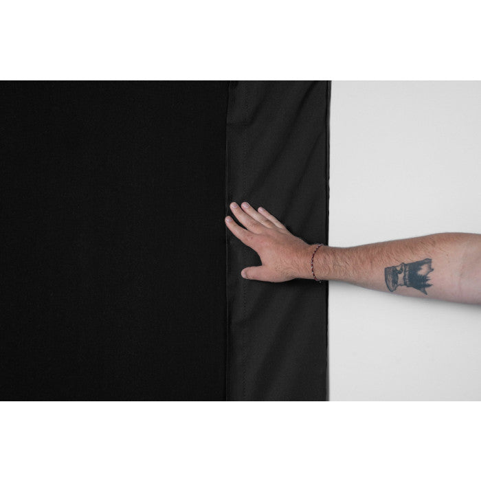 Close up of a hand adjusting the black fabric flap where it meets the white impact screen on Carl’s Pro Golf Simulator Enclosure Kit